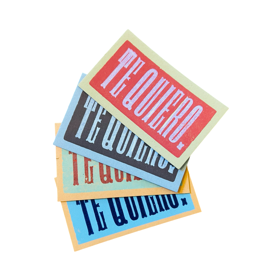 A stack of colorful mini cards with the phrase "Te Quiero" printed in bold, vintage-style lettering.