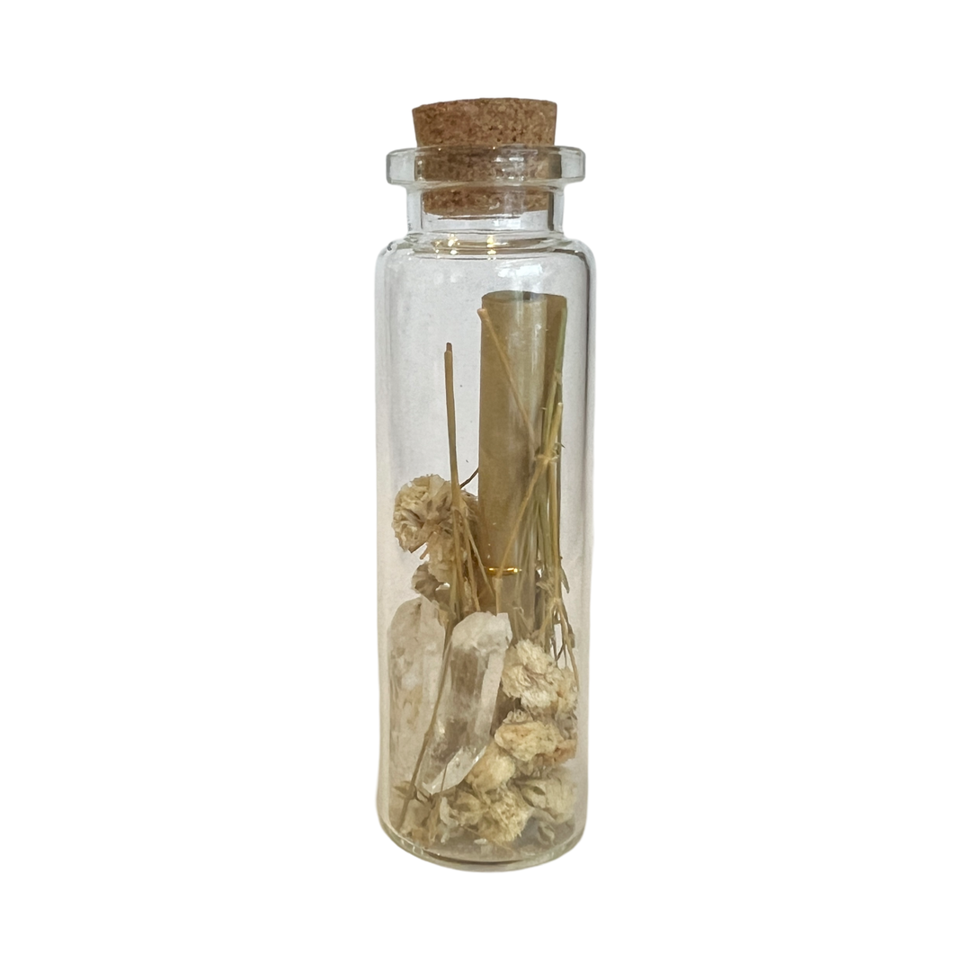 Clear bottle with a cork topper that contains a sprig of lavender, two crystals and a scroll of paper