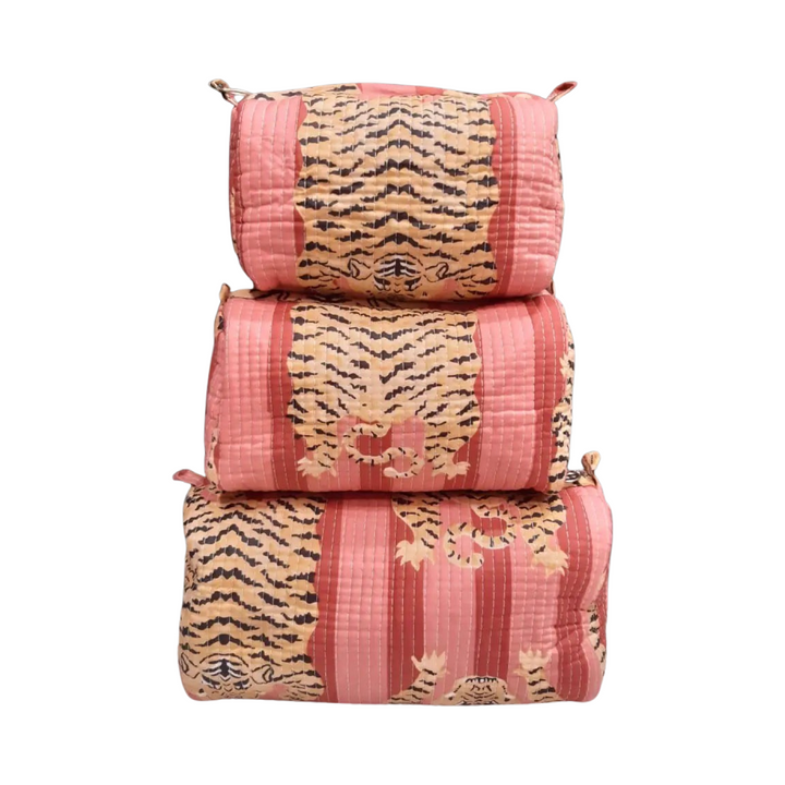 set of three cosmetic bags featuring a coral and pink and tiger-striped pattern.