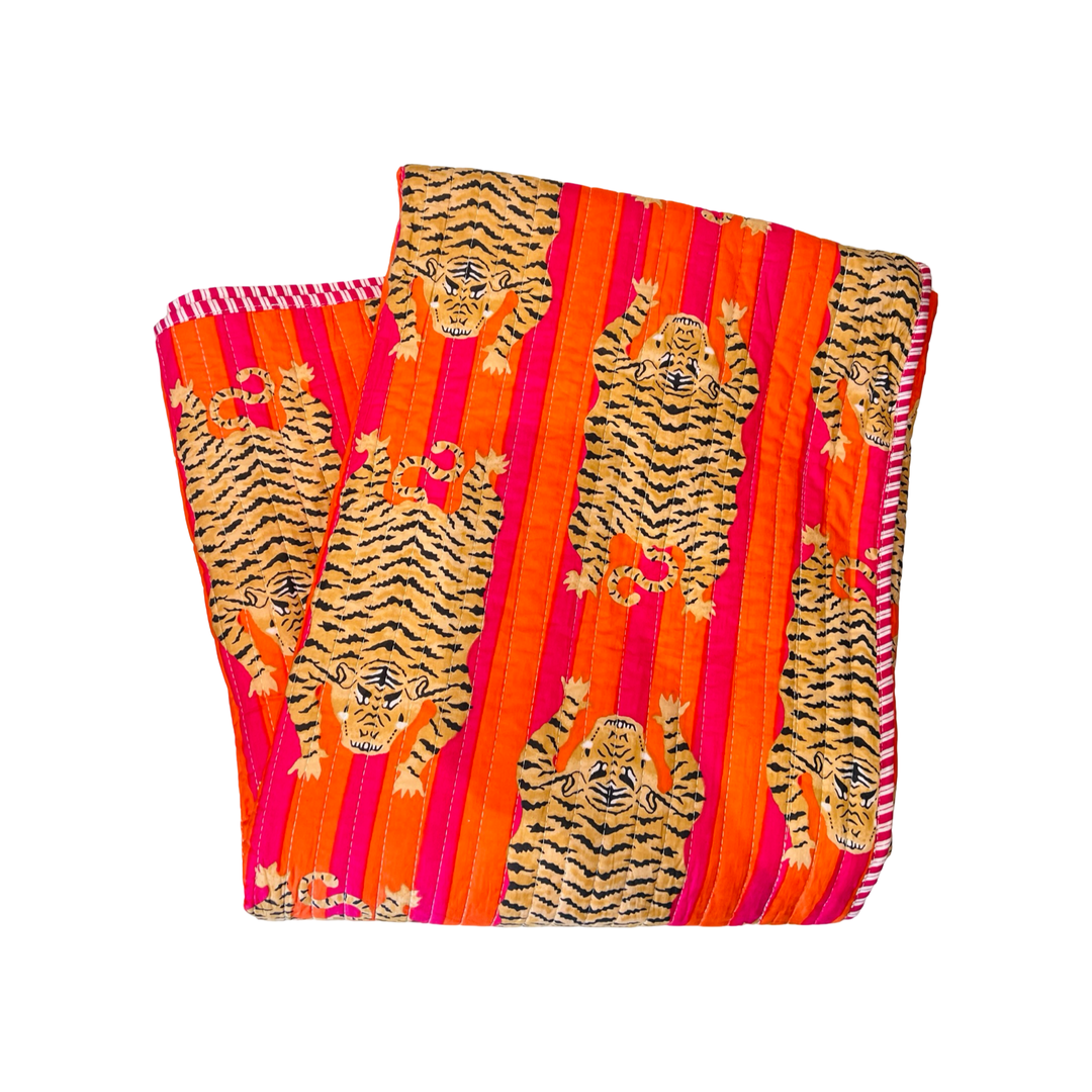 blanket folded in quarters with  a orange and pink and tiger-striped pattern.