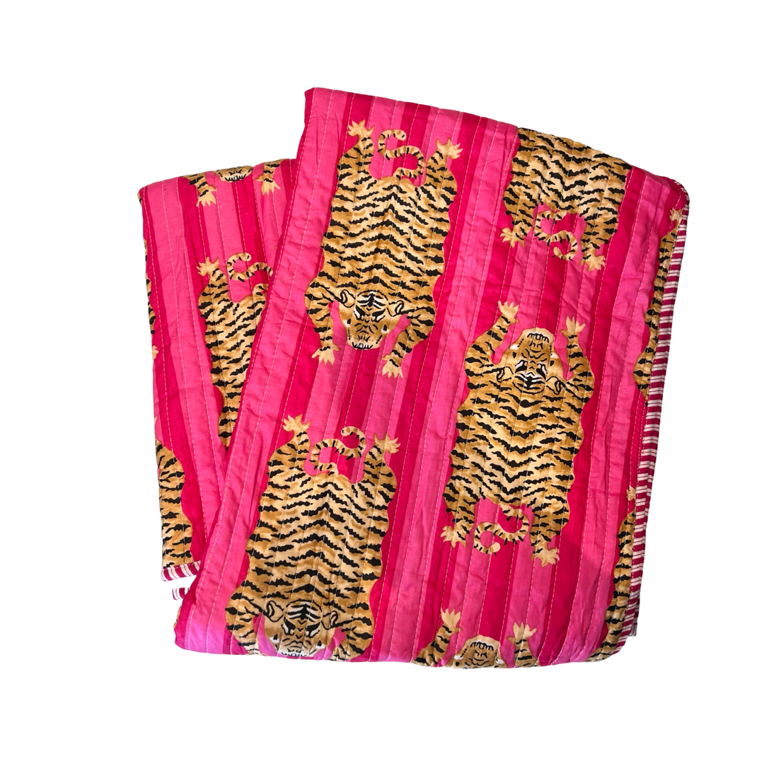 blanket folded in quarters with a pink and tiger-striped pattern.