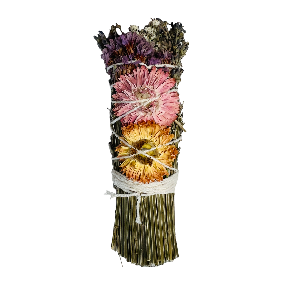 smudge bundle with lemongrass, lavender, and a pink and orange dried flower tied with white twine