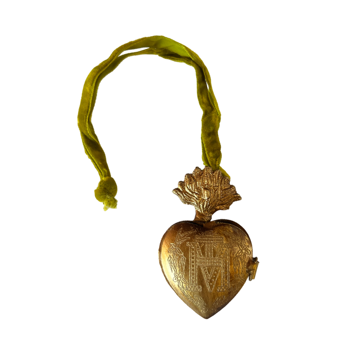 brass heart locket featuring an engraved design with a green velvet hanging loop