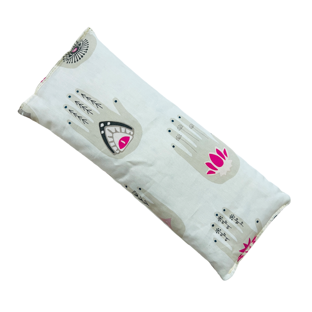 white rectangle eye pillow featuring a light gray with black and pink details hamsa hand repeated pattern.