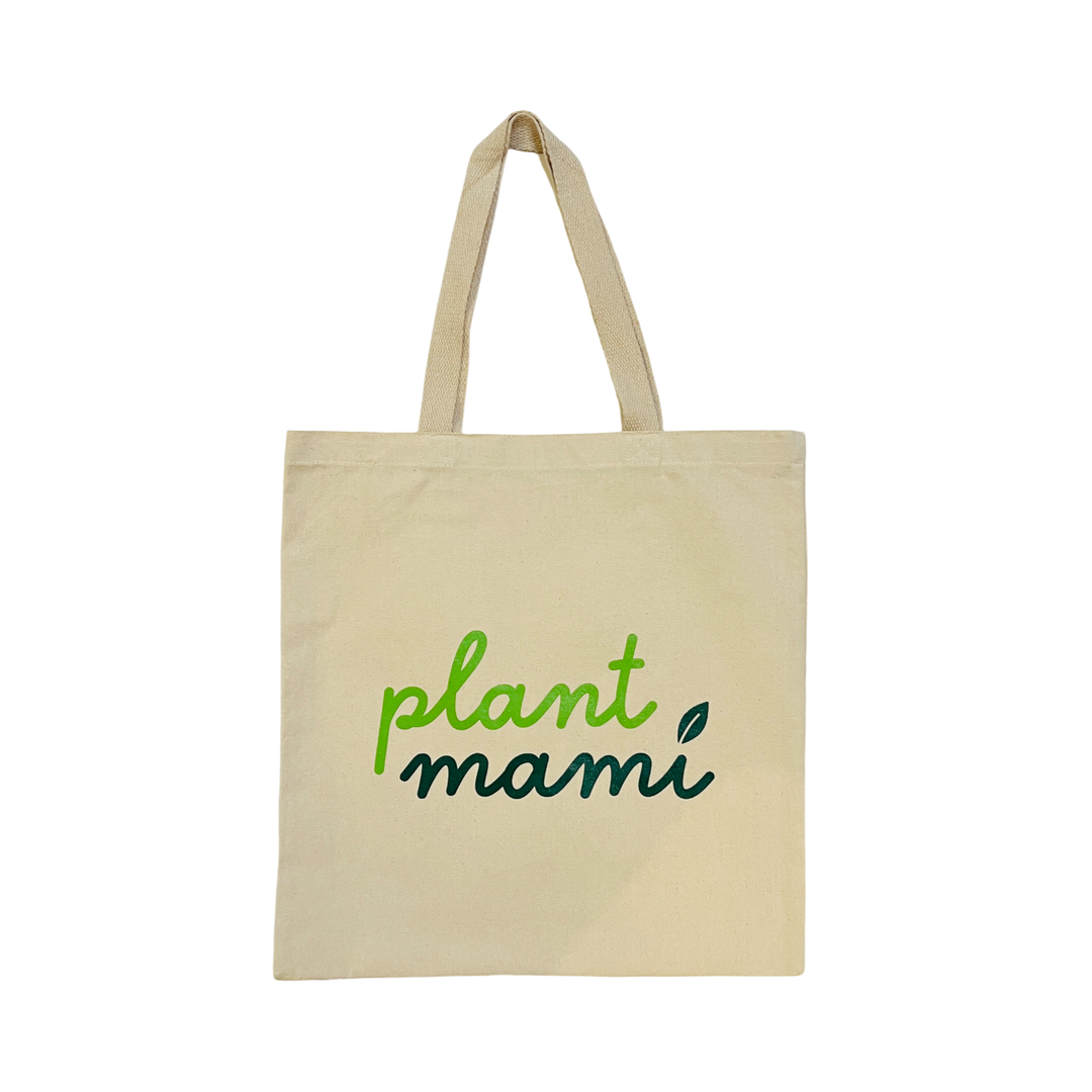 natural canvas tote bag with the phrase Plant Mami in two shades of green with a leaf dotting the "i" in mami.