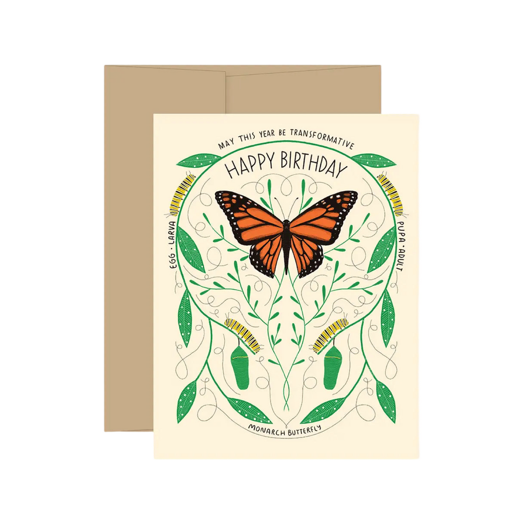 cream colored card with the metamorphosis of a monarch butterfly featuring a design with a monarch butterfly, catepillars and foliage. The phrase May This Year Be Transformative Happy Birthday in black lettering.