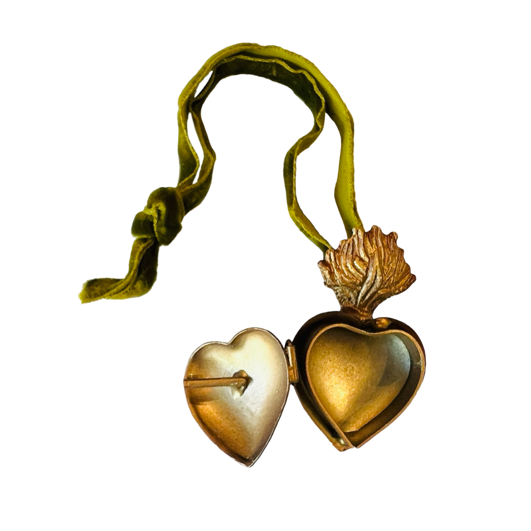 Opened brass heart locket with a green velvet hanging loop