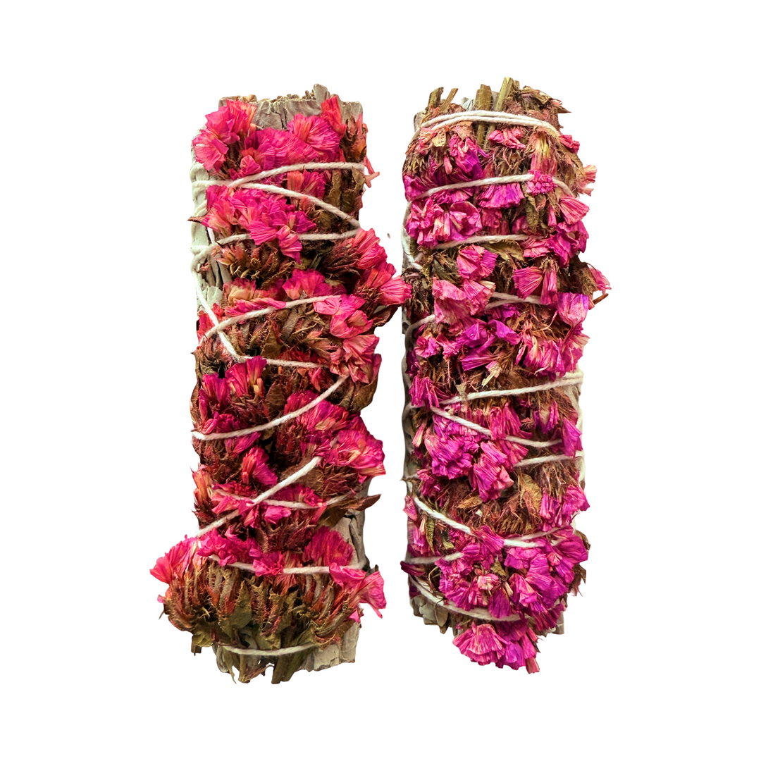 set of sage bundles with various shades of pink sinuata flowers wrapped with white twine.
