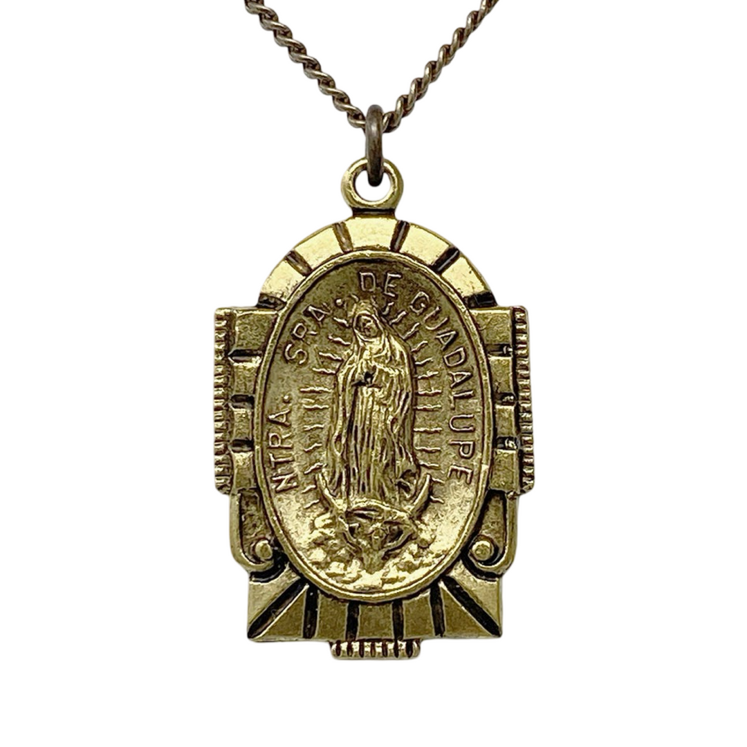 close up view of a pendant that  features an image of the Virgin Mary