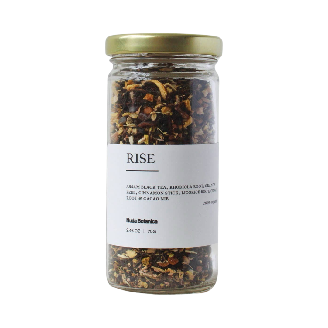 2.46 oz clear jar of dried flowers, herbs and cacao nibs tea with a white branded label with black lettering. Brand: Nuda Botanica