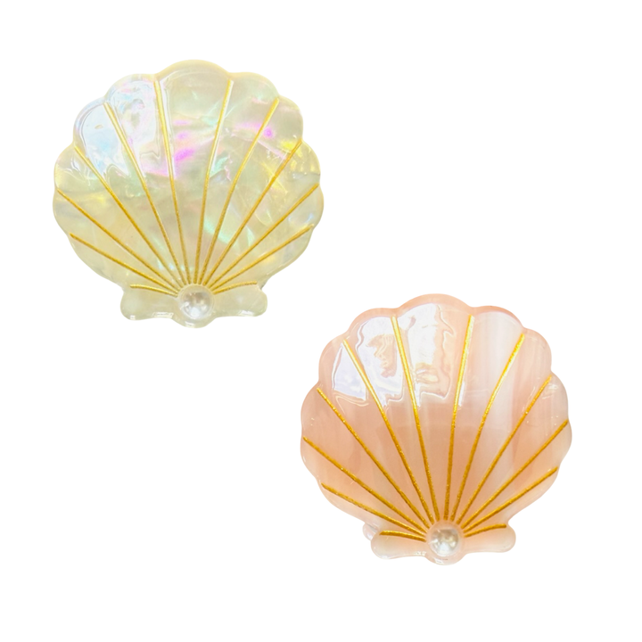 set of Iridescent seashell-shaped hair claw clip, one white and one peachy, with gold detailing and a pearl accent.