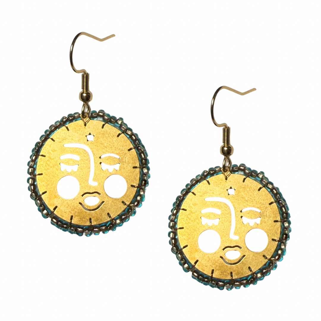 Brass circular drop earrings with a cutout moon face design and turquoise beaded border.