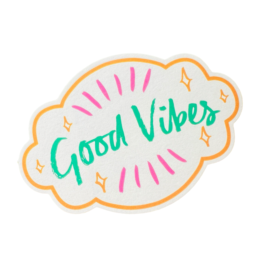 white sticker with an orange outline and the phrase Good Vibes in green lettering featuring orange and pink designs.