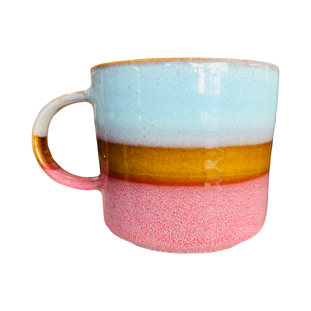 Stoneware mug featuring watery blues, sandy hues, and rosy pink colors.