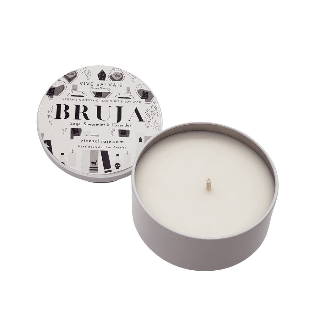 white round tin candle with its lid on the side