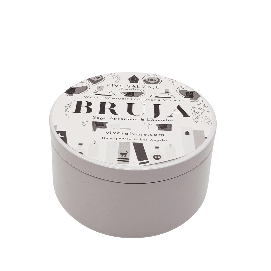 white round tin candle with a white and black branded label
