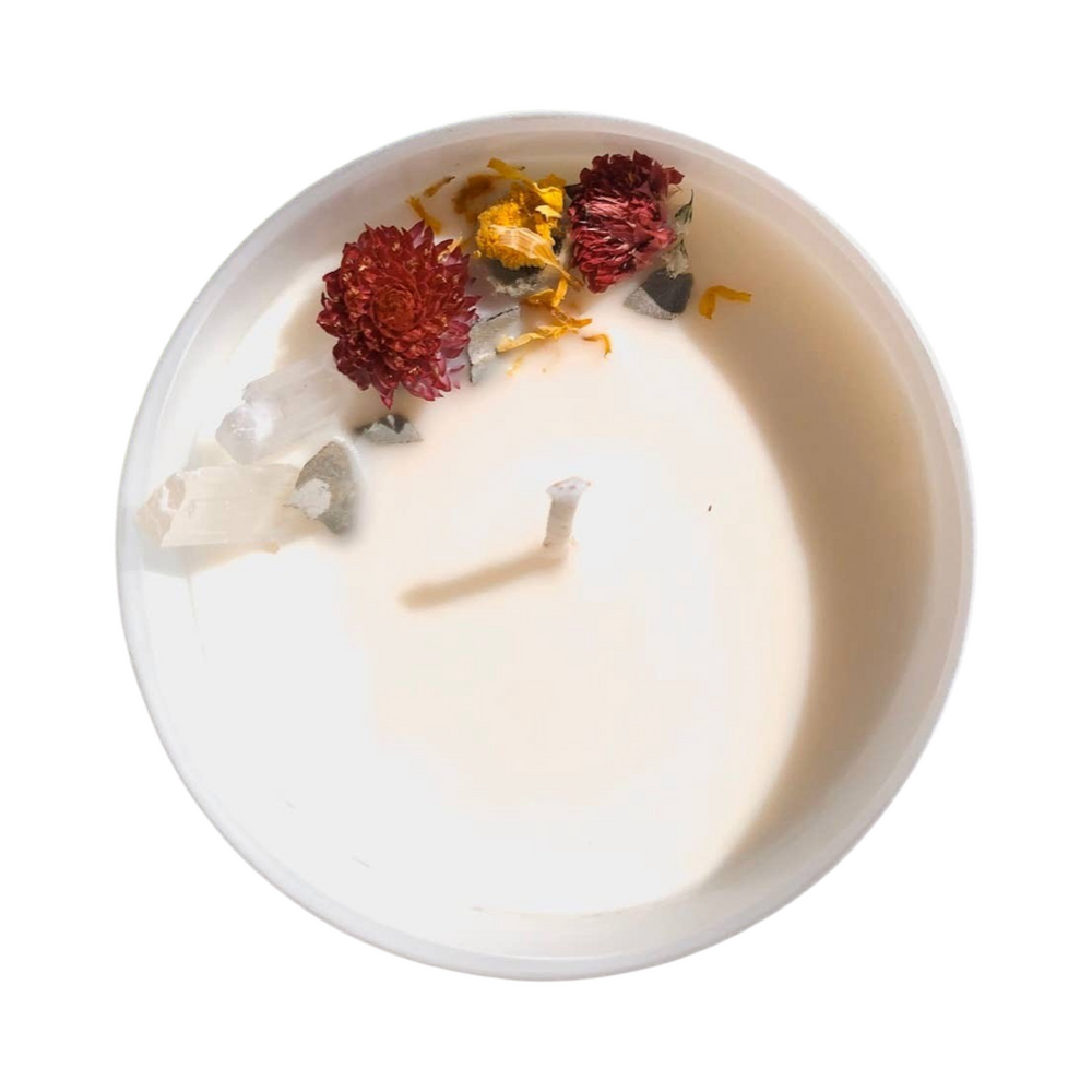 top view of a white candle with dried flowers and crystals