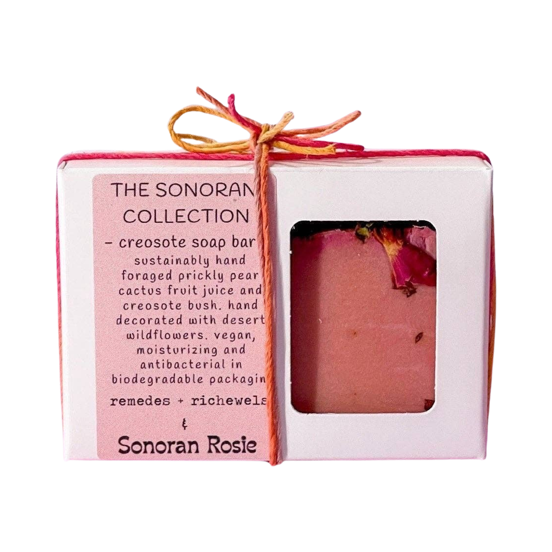 pink bar of creosote soap in a white box with a pink branded label and tired with pink and yellow twine