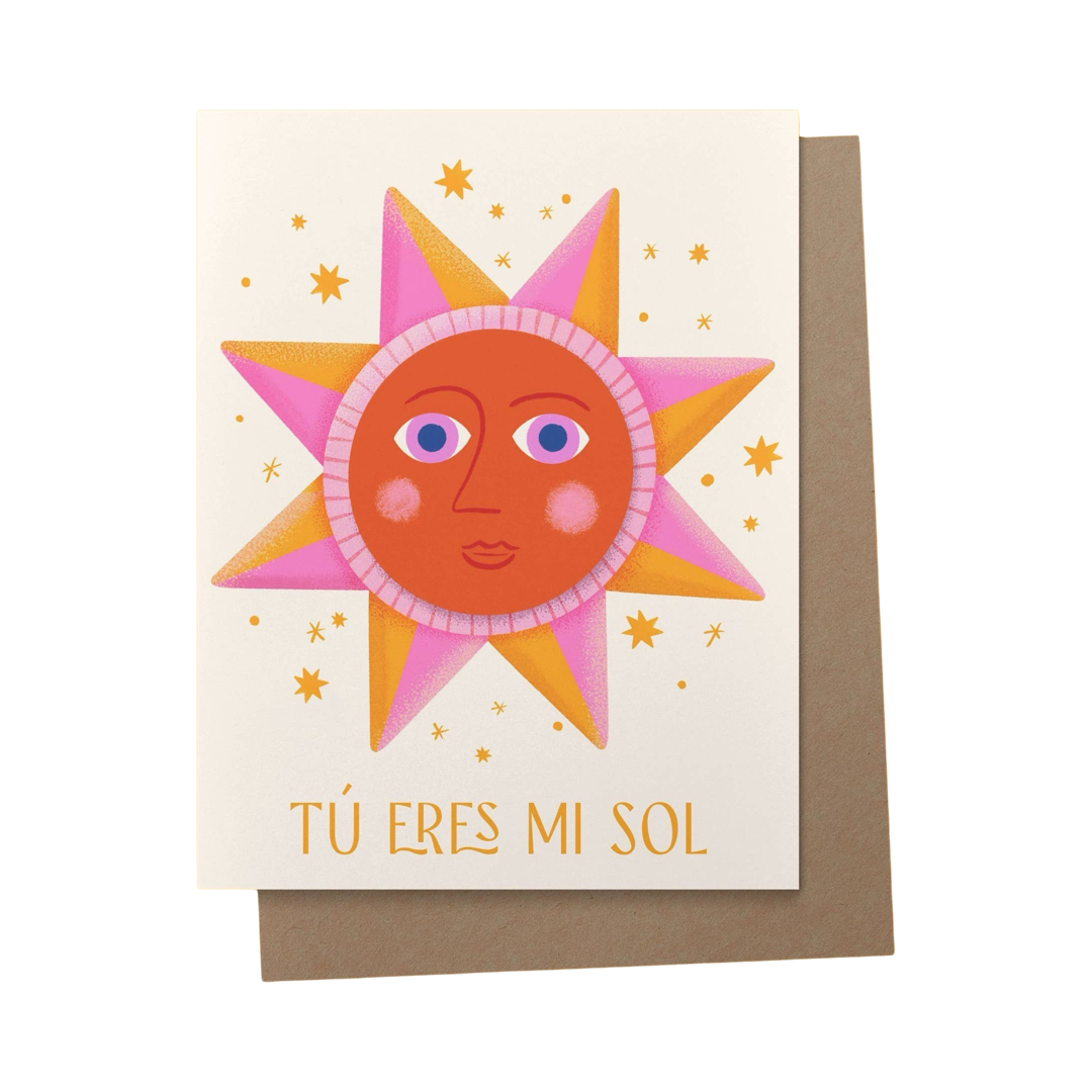 brown envelope behind a cream card with an orange and pink illustration of a sun with gold stars and the phrase Tu Eres Mi Sol in yellow lettering