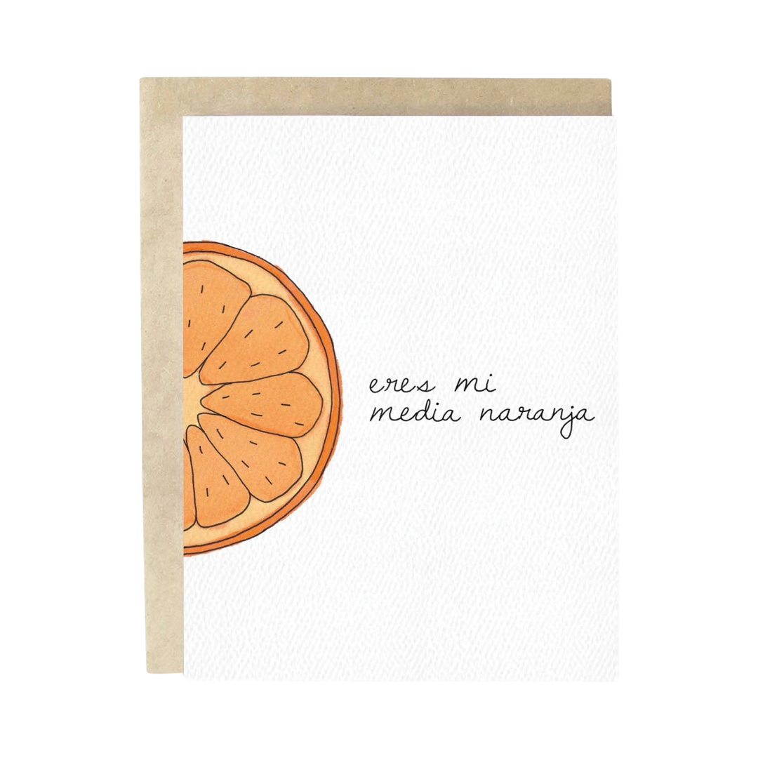 brown envelope behind a white texured card with an illustration of half an orange and the phrase Eres Mi Media Naranja