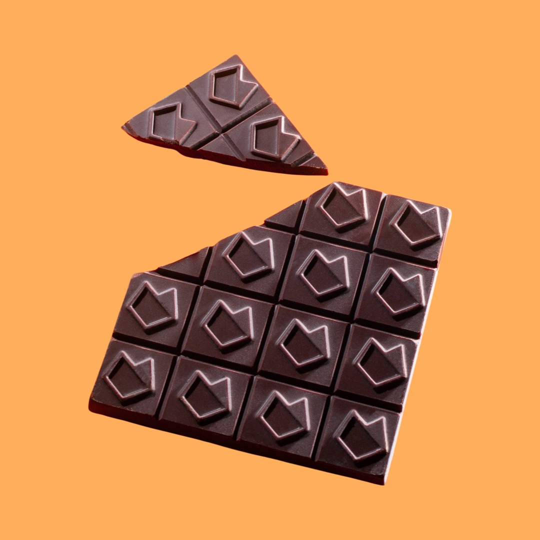 square chocolate bar with a design on each square and a corner broken off with an orange background