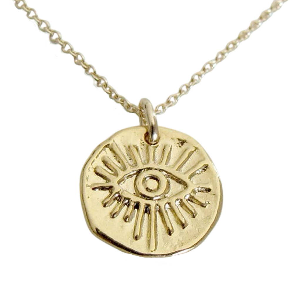 close up of a gold medallion with an image of an eye on a gold chain