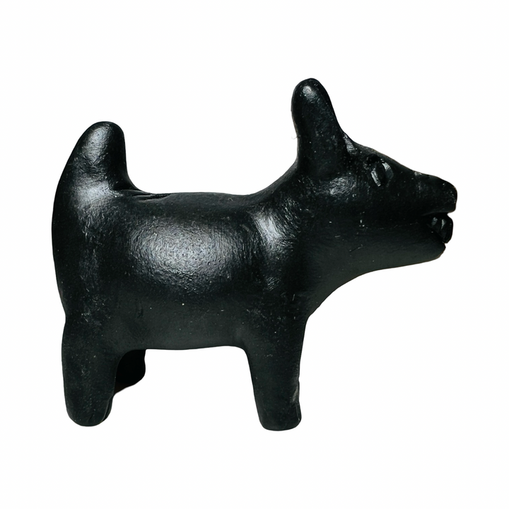 side view of a black clay dog figurine