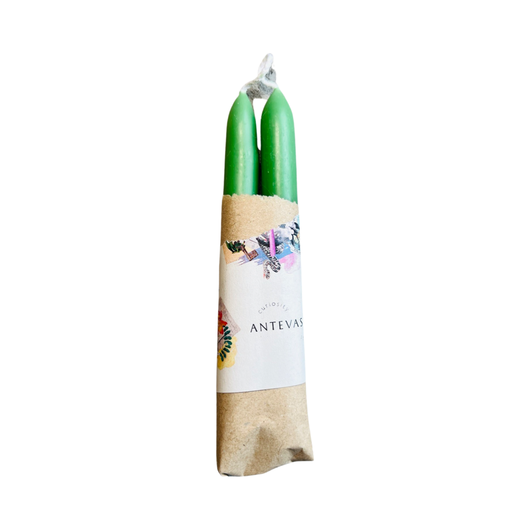 set of green candles wrapped in kraft paper and a piece of branded paper.
