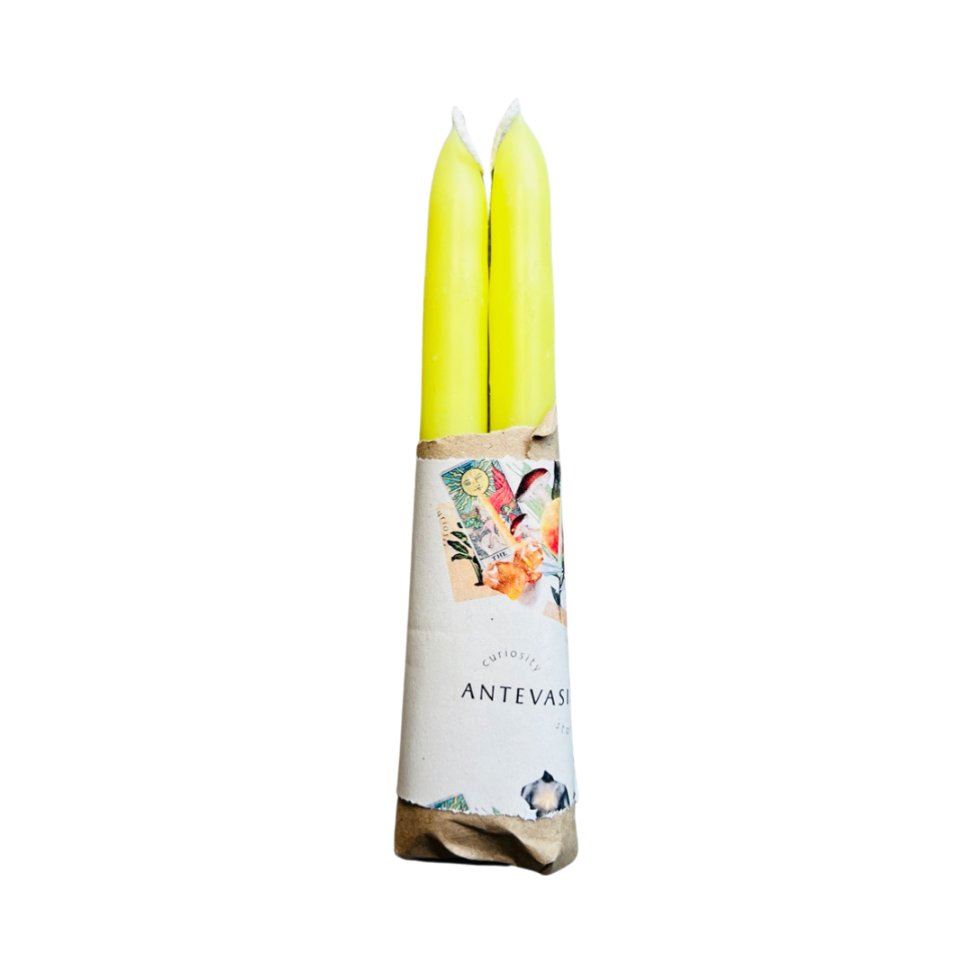 set of yellow candles wrapped in kraft paper and a piece of branded paper.
