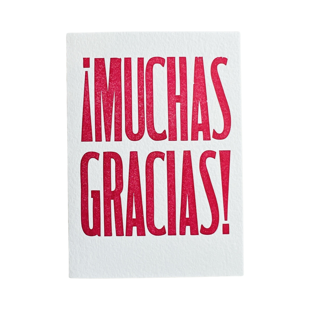 white card with the phrase Muchas Gracias in red lettering