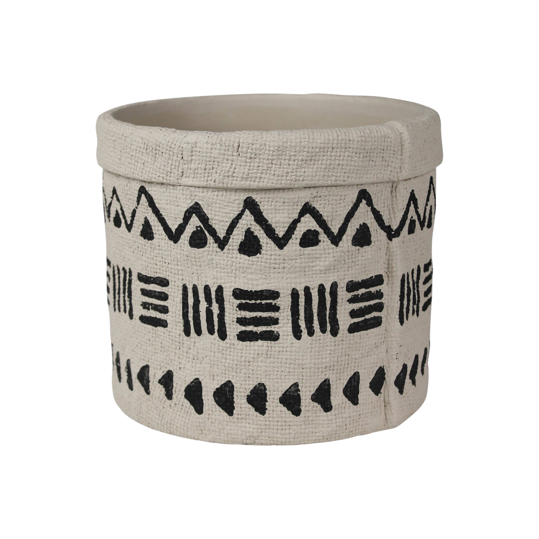 cement cylinder cachepot with black designs that feature triangles, lines and dots.
