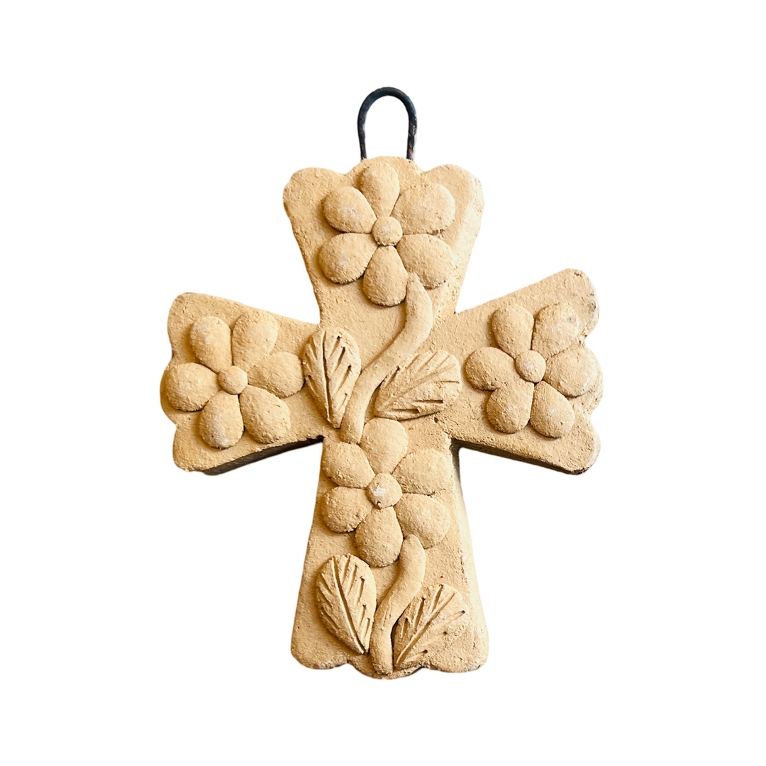 barro clay cross with a floral design and a wire loop for hanging.