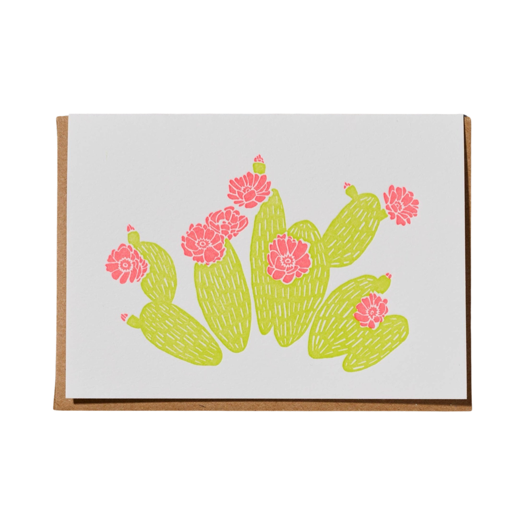 white card with a brown envelope with an illustration of green cacti and pink flowers.