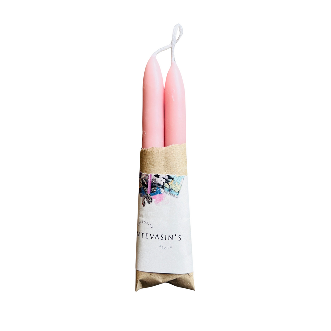 set of pink candles wrapped in kraft paper and a piece of branded paper.