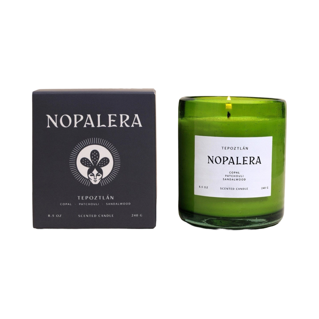 8.5 oz green vessel candle with a white branded label alongside a black branded box