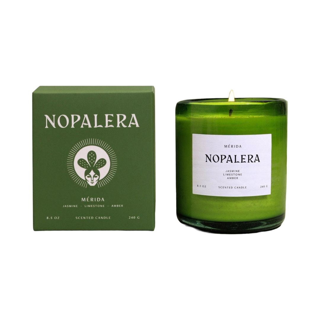 8.5 oz green vessel candle with a white branded label alongside a green branded box
