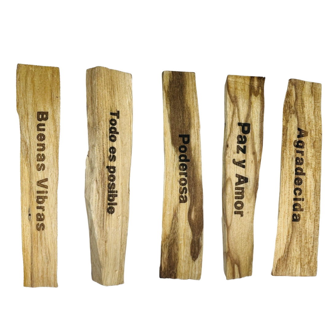 5 sticks of palo santo lined up in a row with each stick engraved with one of the following phrases: Buenas Vibras (Good Vibes), Todo Es Posible (Everything is Possible), Poderosa (Powerful), Paz y Amor (Peace and Love) and Agradecia (Grateful)