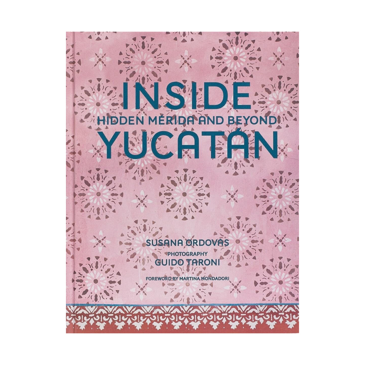 Book cover of 'Inside Hidden Mérida and Beyond Yucatán' with decorative patterns on a pink background. Blue large title text sits at the top half of the text while the author and other credits are in smaller text at the bottom center.