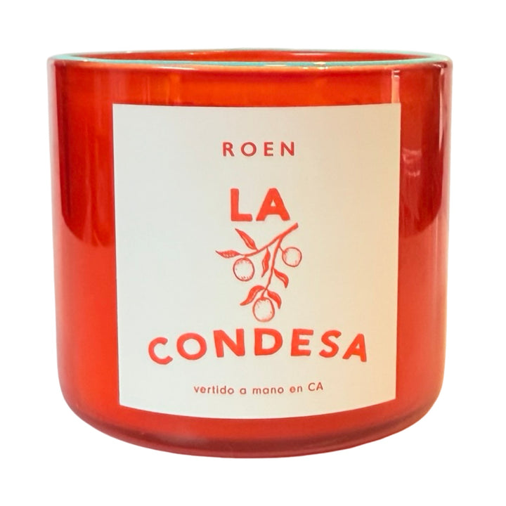 Photo of orange candle jar with branded label that reads "Roen - La Condesa - Vertido a mano en CA"