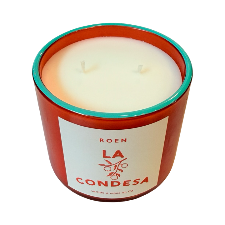 Top view of orange candle jar with branded label that reads "Roen - La Condesa - Vertido a mano en CA"