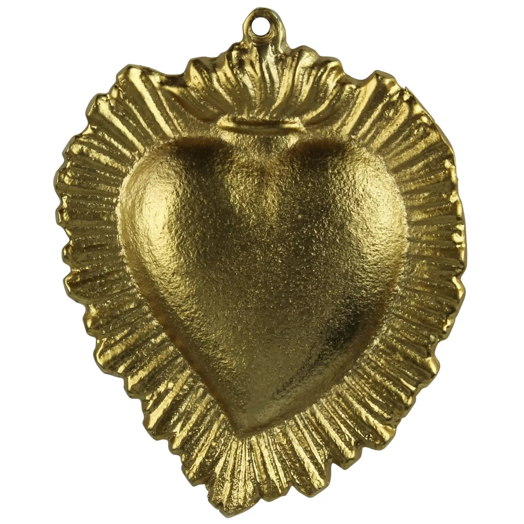 A gold-colored brass Milagro Sacred Heart charm with a textured surface and a small ring at the top for hanging.