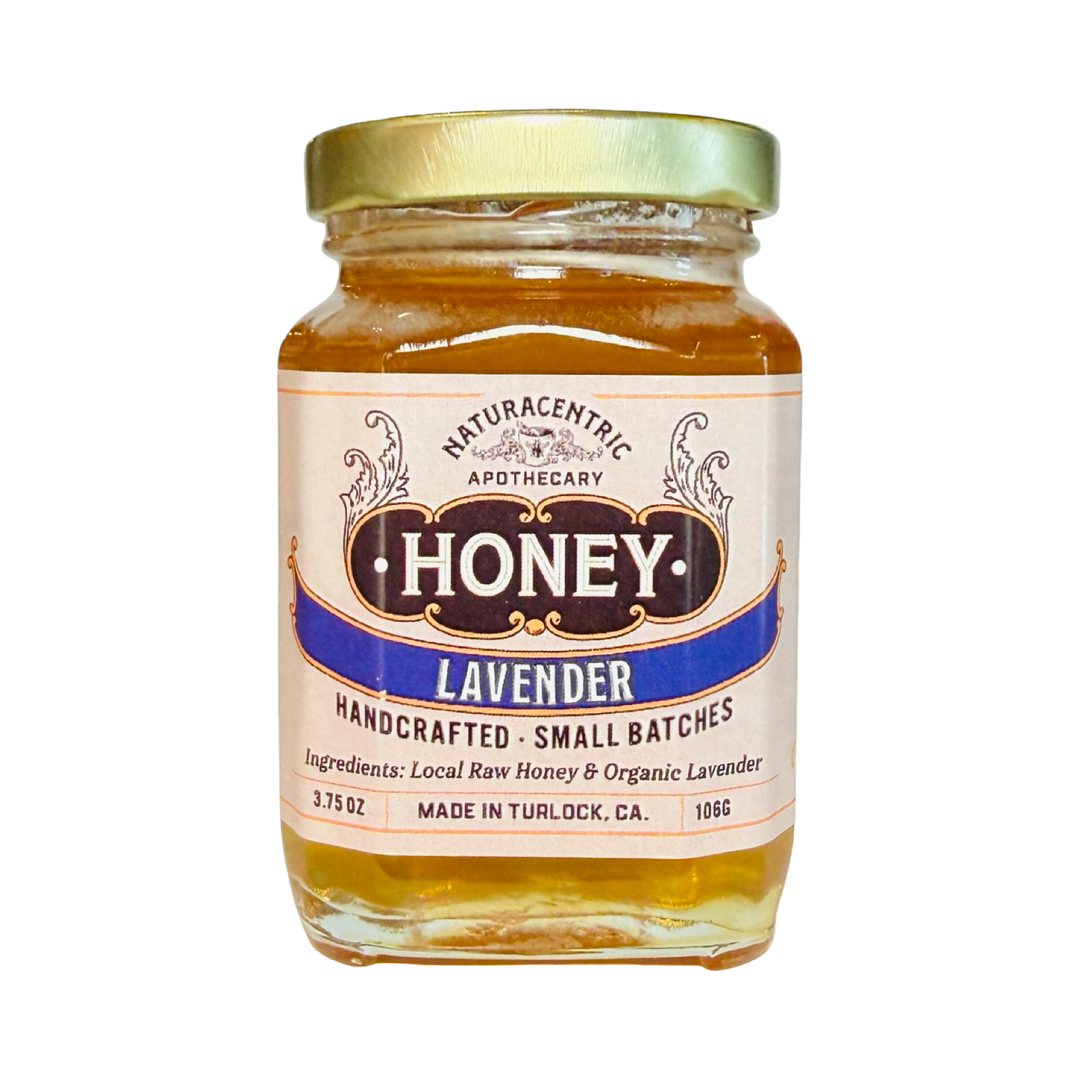 A 3.75 oz glass jar of Naturacentric Apothecary Lavender infused honey with a gold lid and vintage-style label,