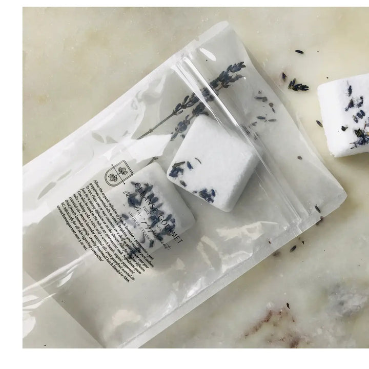 Alternate view of plastic pouch of lavender shower steamers by Cleanse Gourmet has package content description in fine black print.