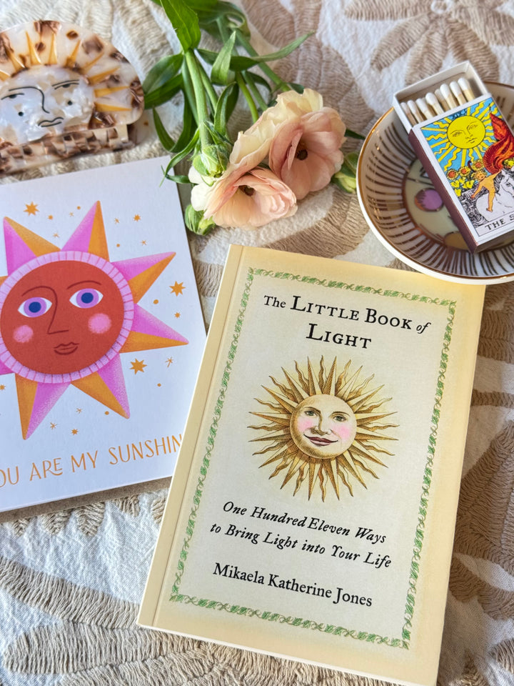 Book titled 'The Little Book of Light' with a sun illustration on a textured surface.