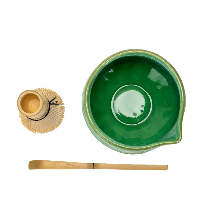top view of a green matcha bowl, whisk and bamboo spoon.