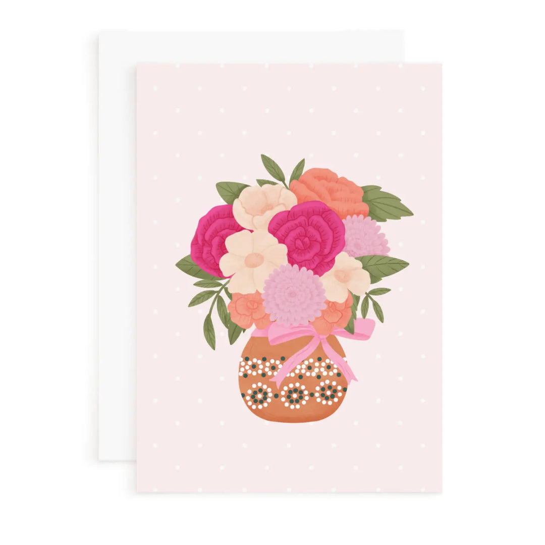 Floral arrangement in a decorative vase on a light pink background