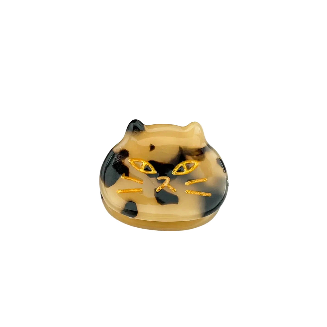 Small tortoiseshell acetate hair claw clip shaped like a cat’s head with golden etched facial details.