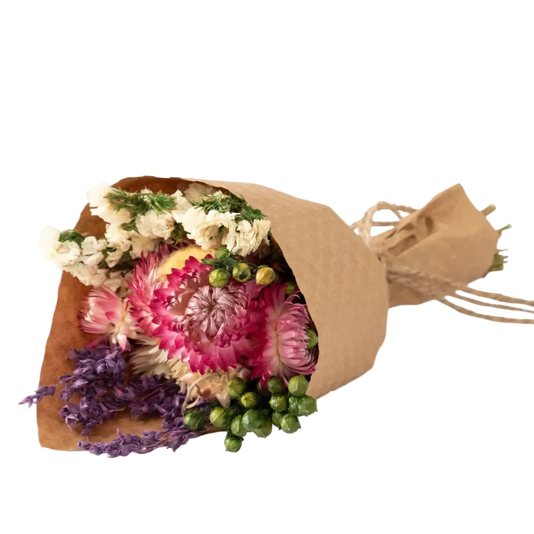 Mini dried bouquet wrapped in kraft paper featuring strawflowers and larkspur blooms arranged in a small bundle.