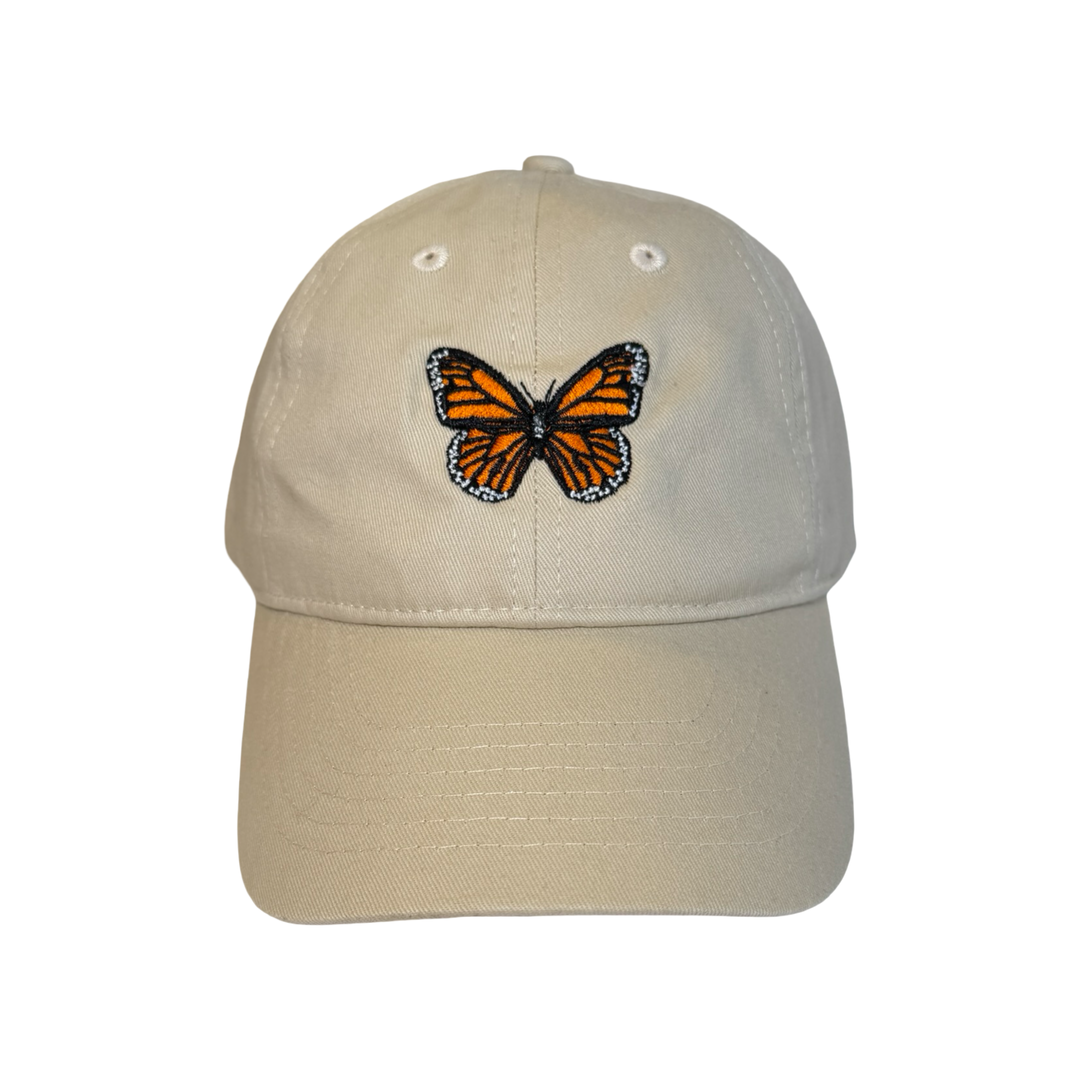 cream hat with a monarch embroidered in the center