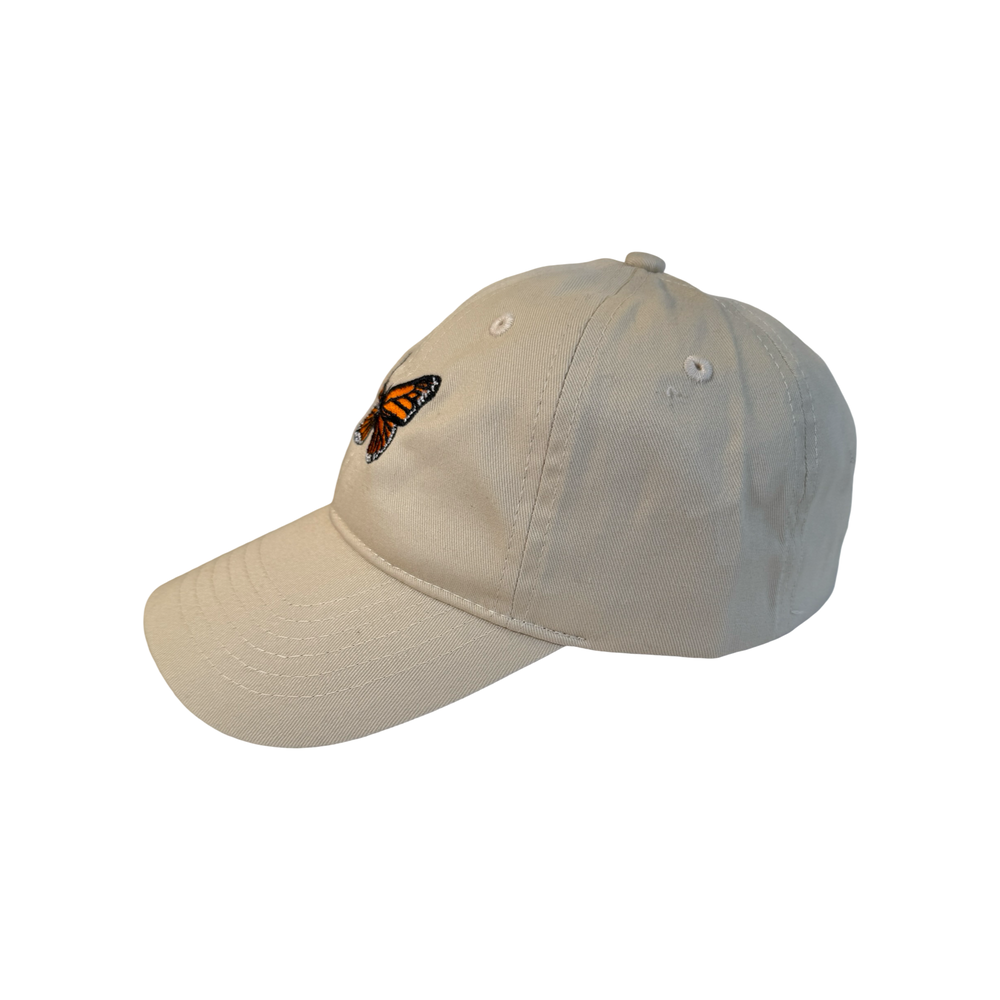 side view of a cream hat with a monarch embroidered in the center